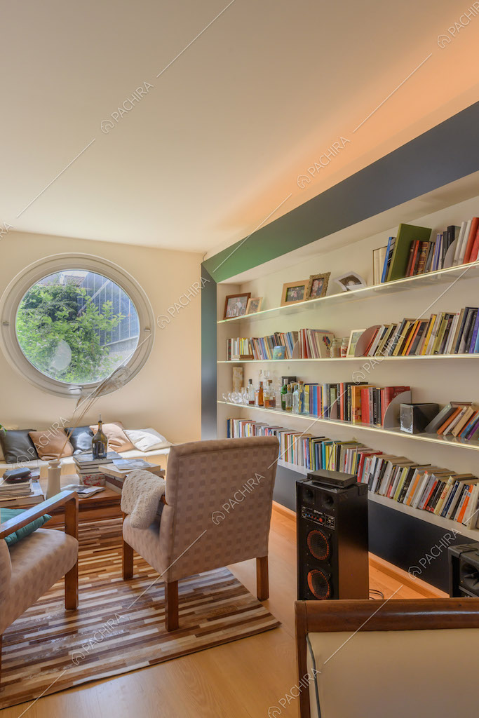 Salotto con divano, poltrone, libreria e pavimento in parquet