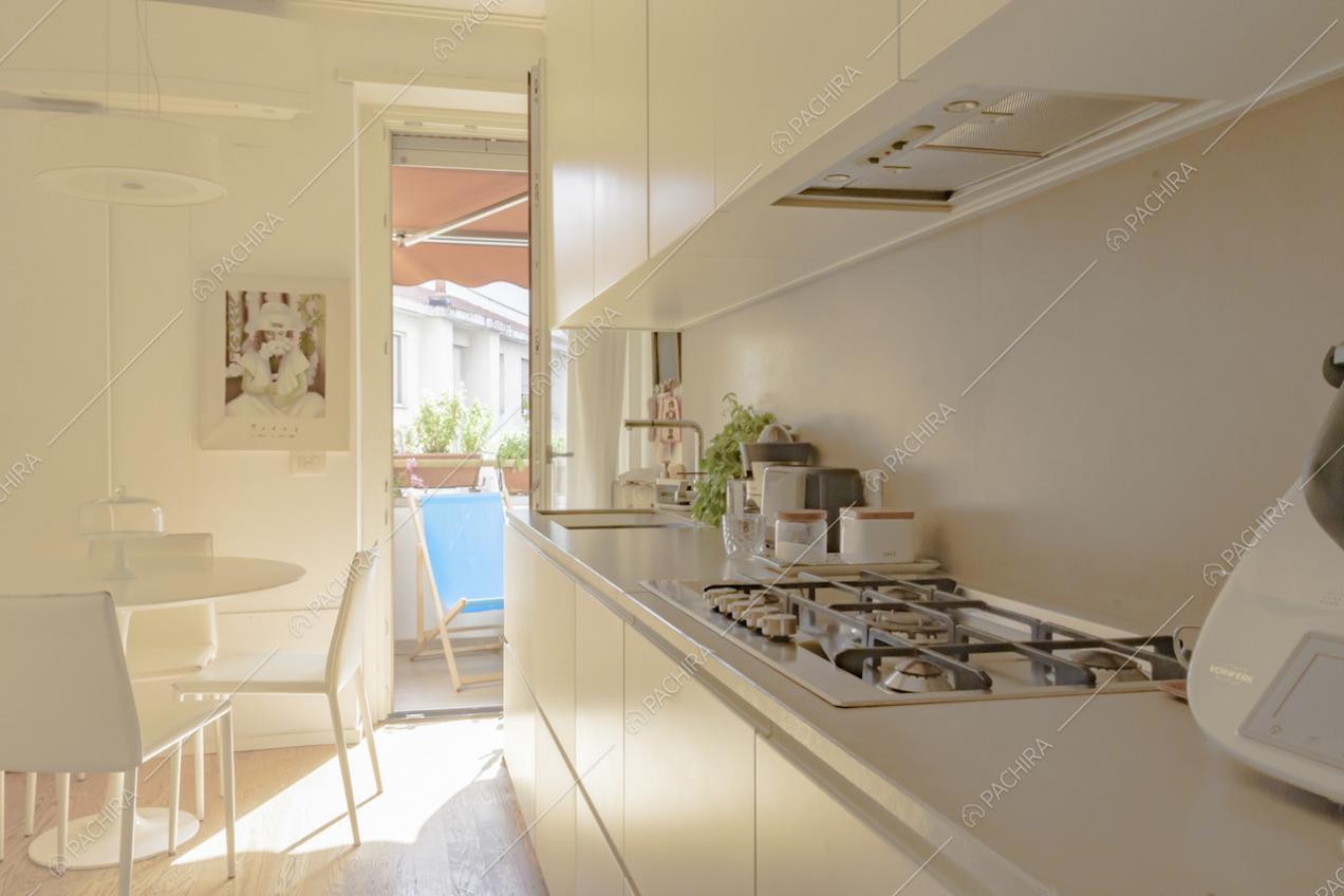 Mobili da cucina bianchi e tavolo tondo con sedie