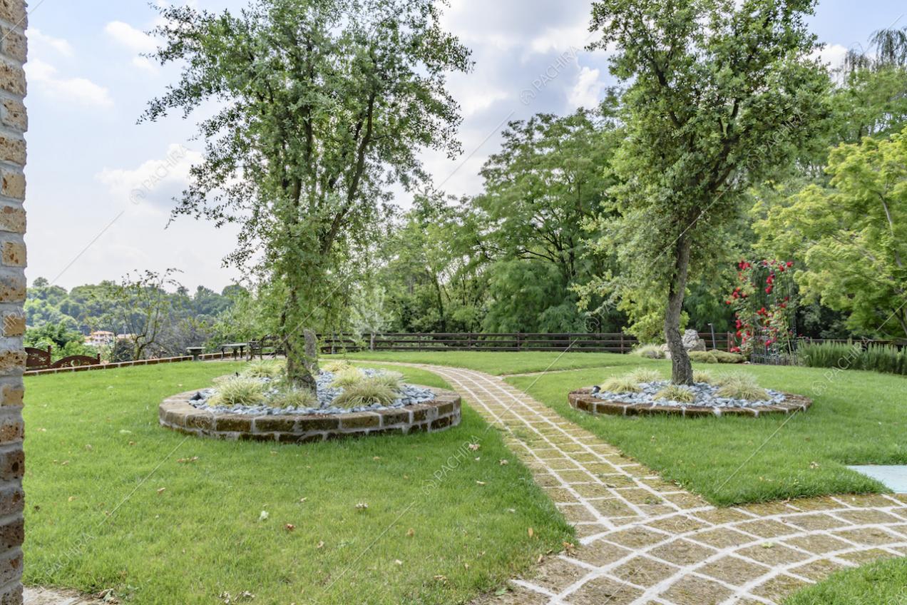 Ampio giardino privato con vialetto in pietra e alberi