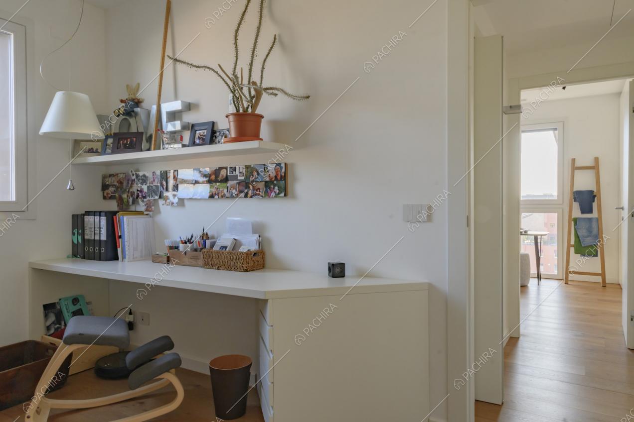Dallo studio con le pareti bianche vista sul corridoio e sulla camera da letto