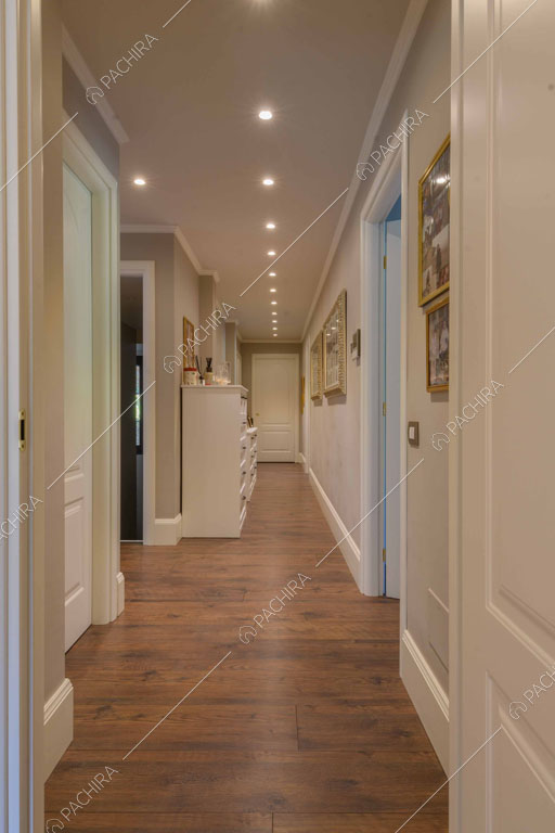 Pareti grigie e pareti bianche con boiserie nel corridoio con pavimento in parquet