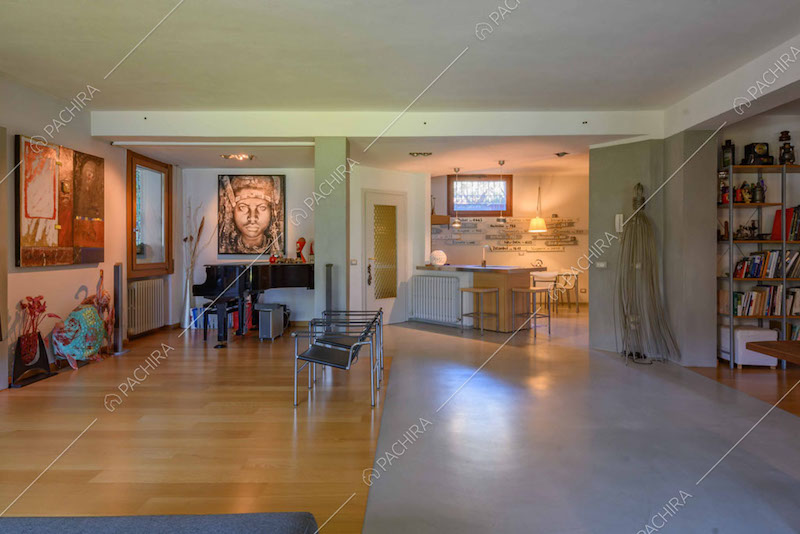 Pavimento in parquet e in cemento lisciato nella zona living con pianoforte