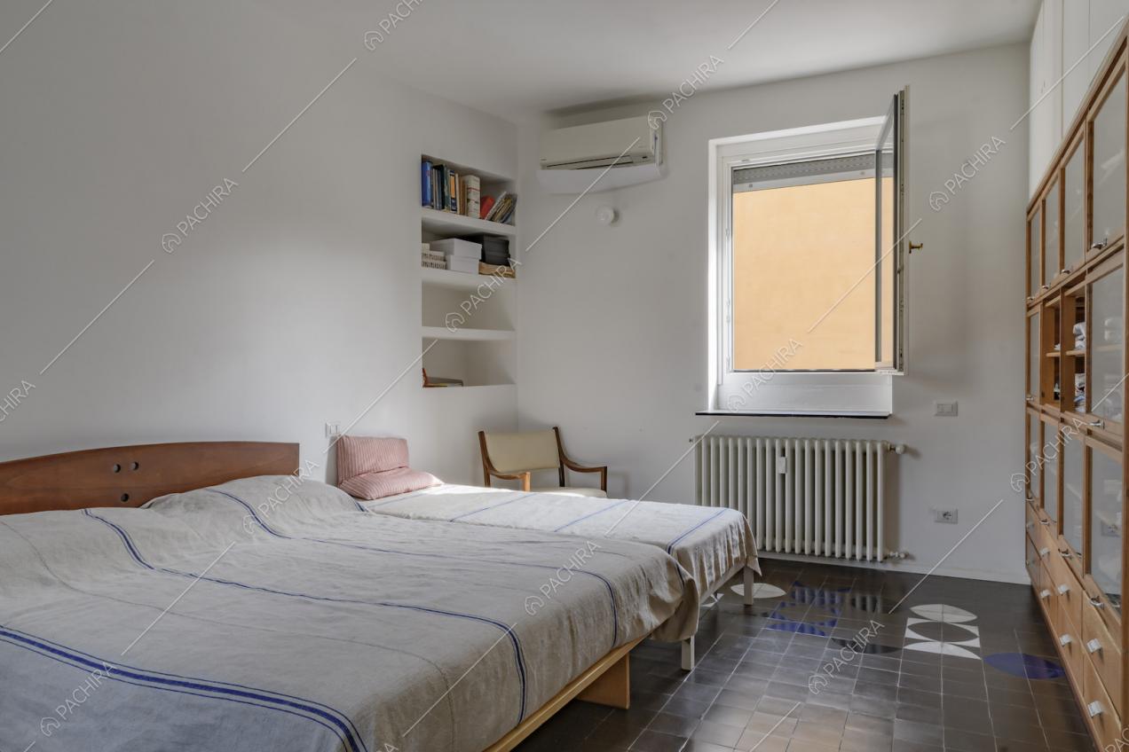 Camera da letto con letto matrimoniale, letto singolo e piastrelle d'epoca anni 70 