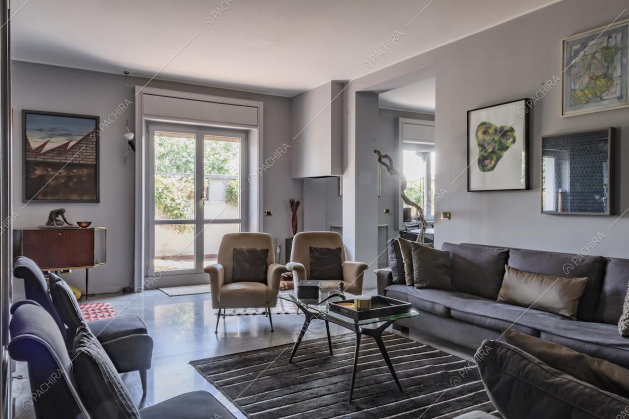 Pareti color grigio chiaro nel soggiorno, divano e poltroncine
