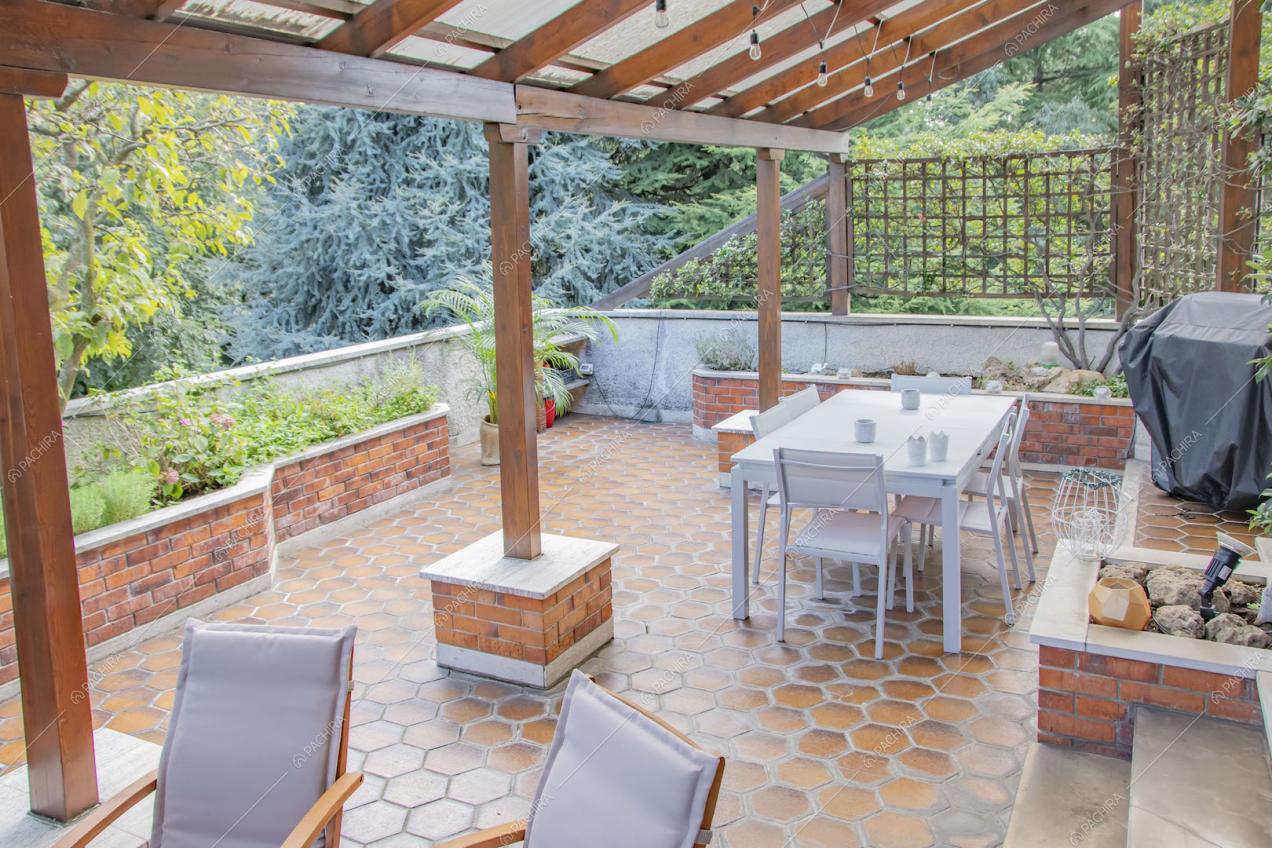 Terrazza con pavimento in cementine e veranda con travi in legno a vista