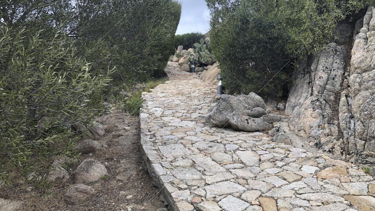 Vialetto con pietre irregolari nel giardino esterno alla villa