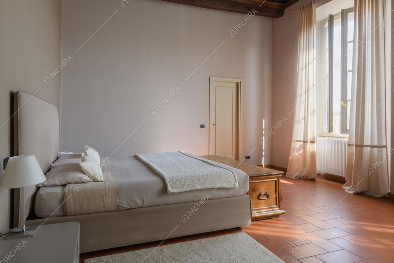 Camera da letto matrimoniale in stile minimal con cassapanca e grandi vetrate