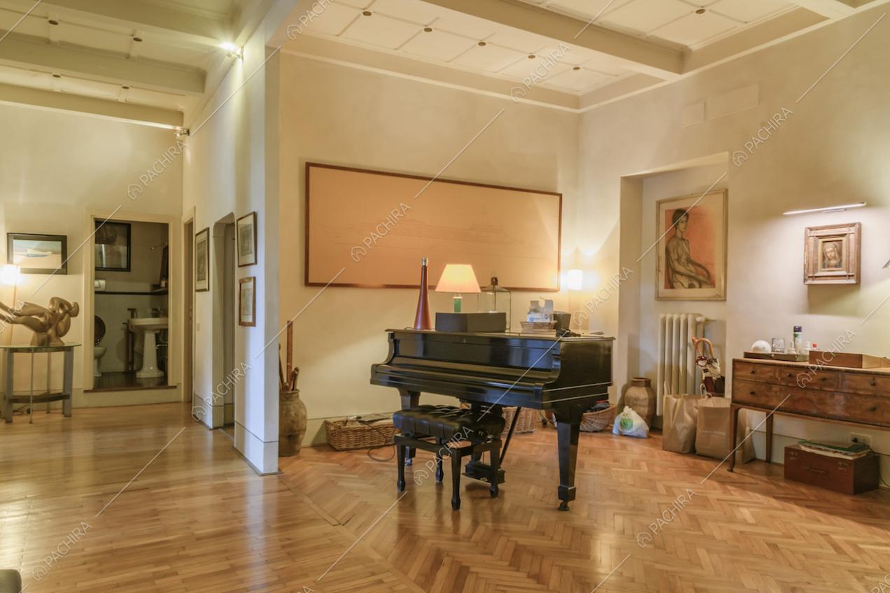 Pianoforte a coda, quadro astratto e mobile antico