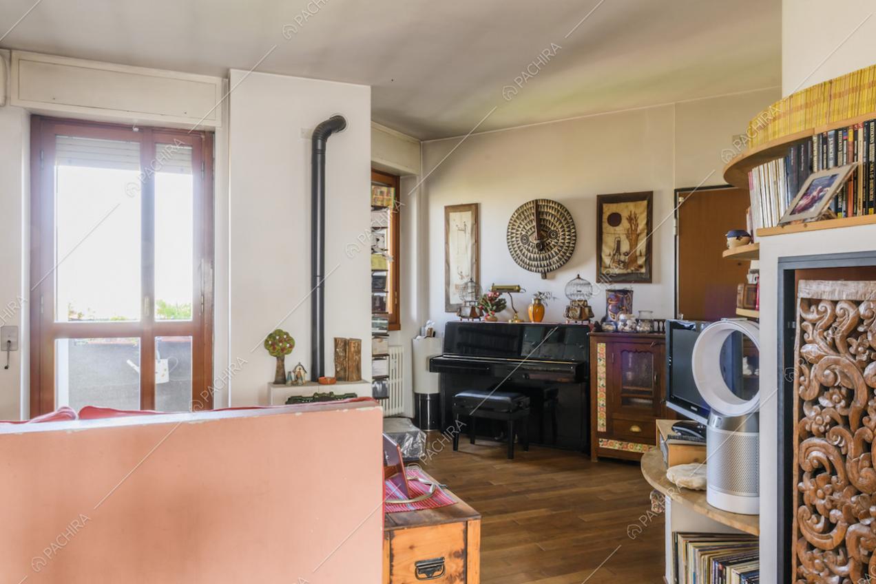 Pianoforte nero sul pavimento in parquet della zona giorno