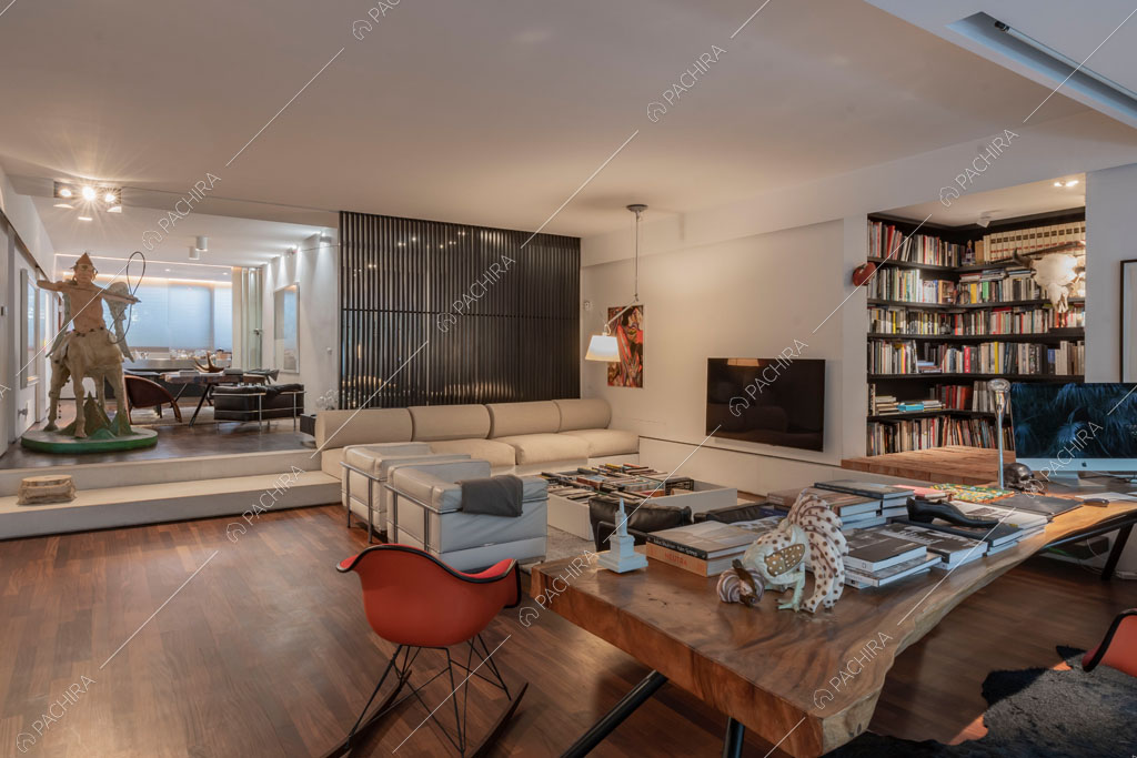 Zona living con libreria dell'appartamento Carpentaria, location in stile contemporaneo a Roma