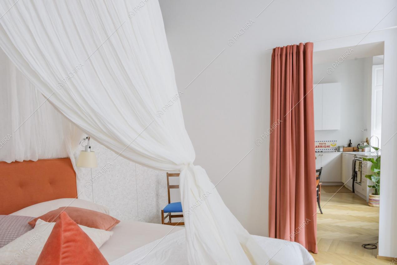 Camera con letto a baldacchino e vista sulla cucina