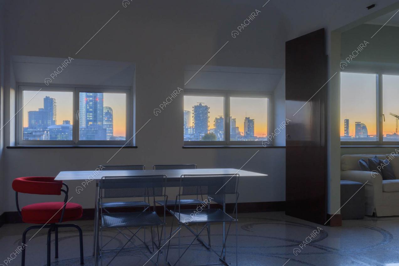 Sala con pavimento in marmo, tavolo in metallo con sedie e vista sullo skyline