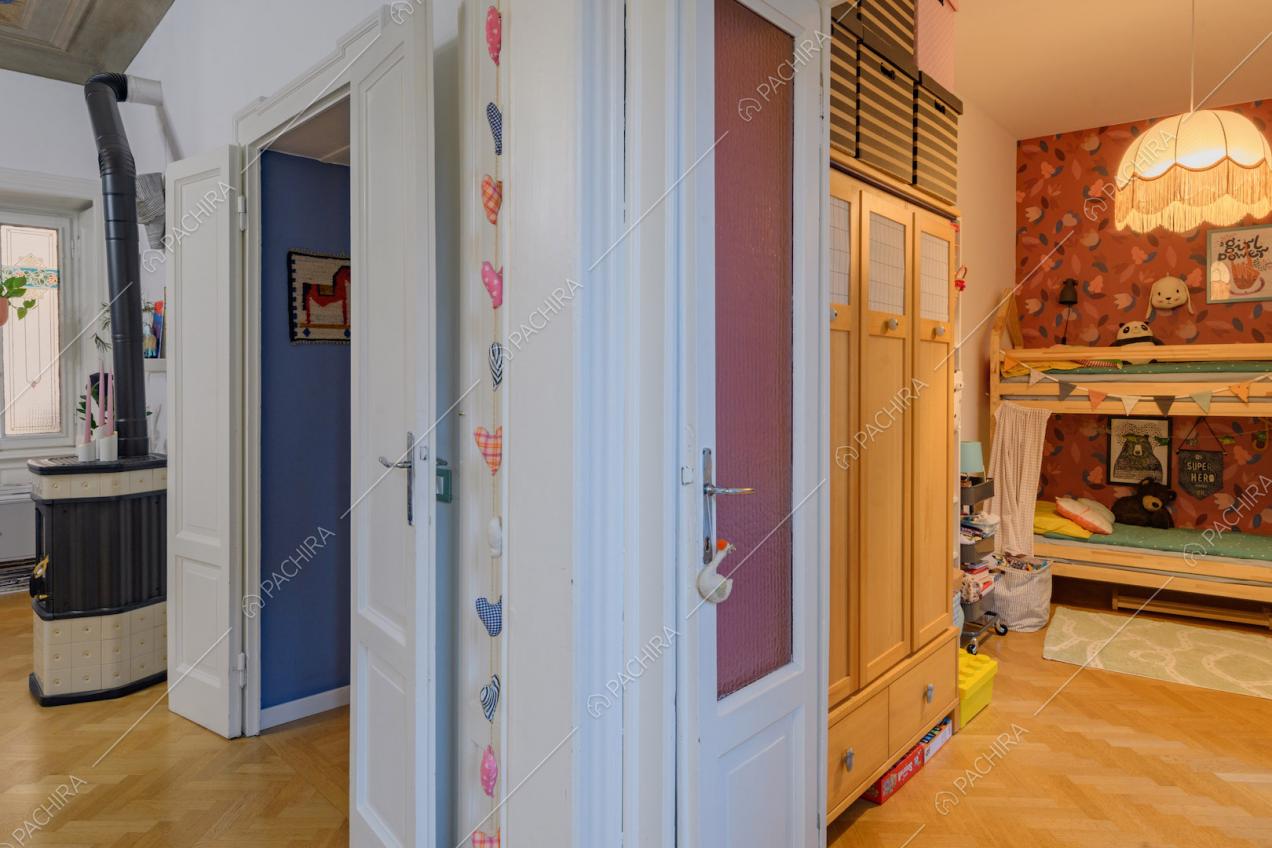 Dalla zona living vista sulla camera da letto dei bambini con carta da parati con fiori