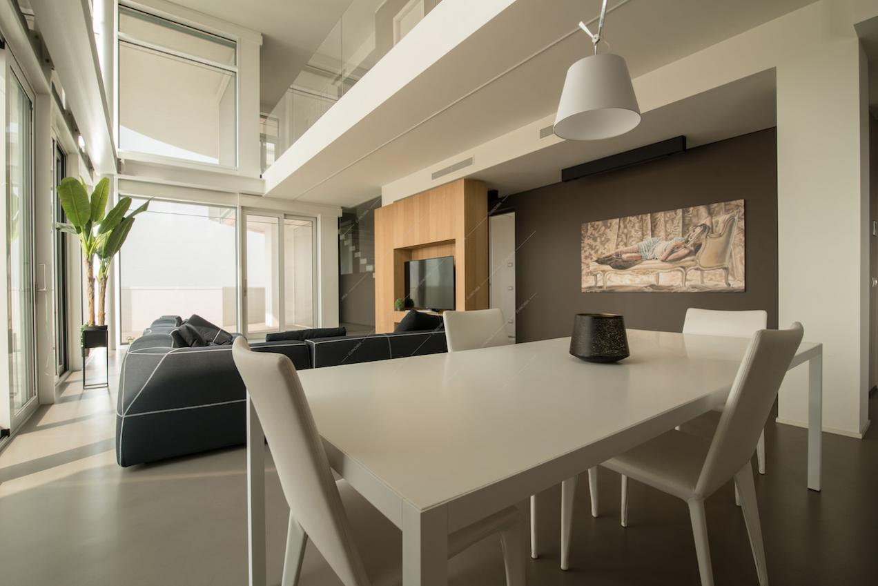 Open space con tavolo da pranzo, divano e quadro