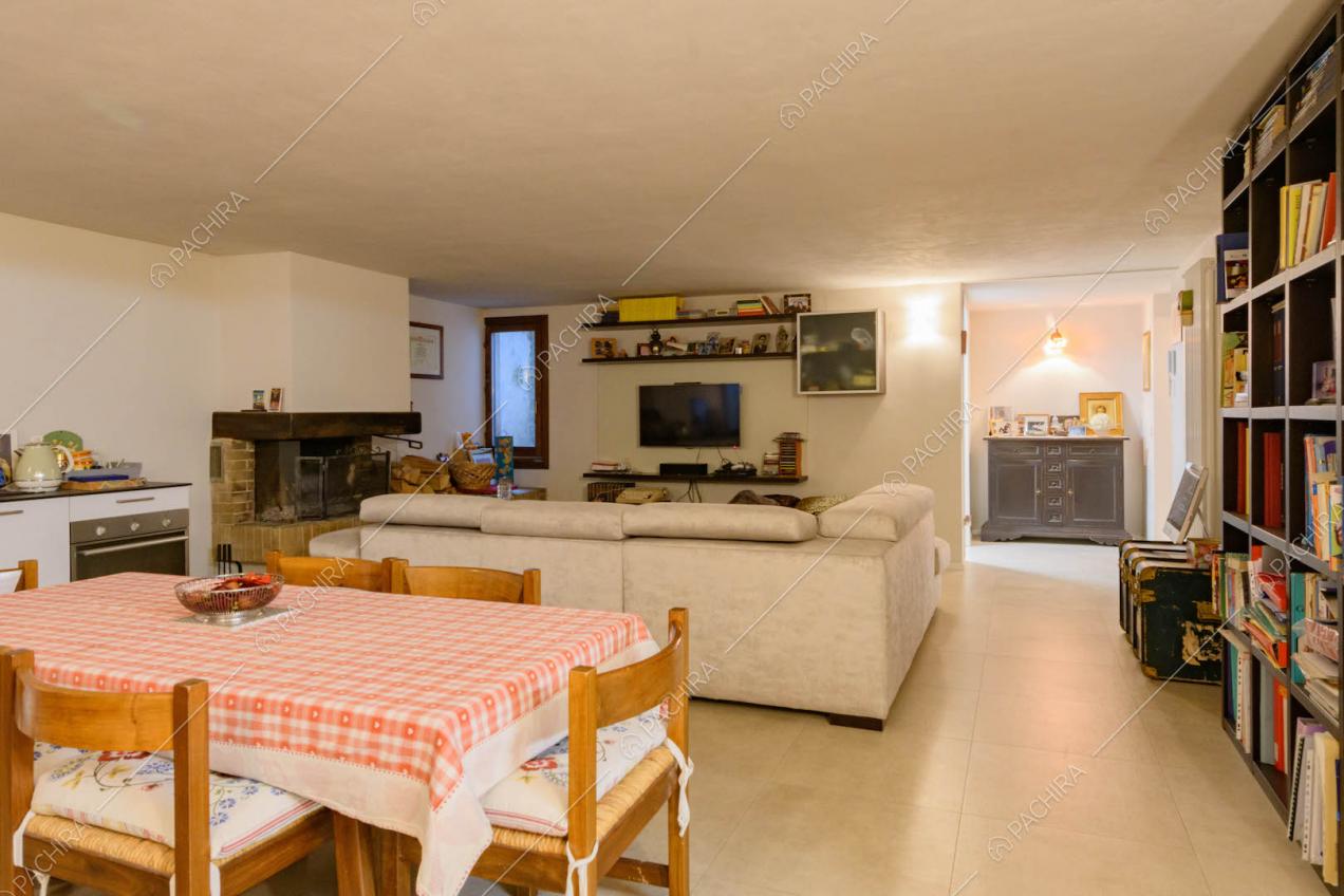 Taverna con pavimento in cemento lisciato, divano, cucina e camino