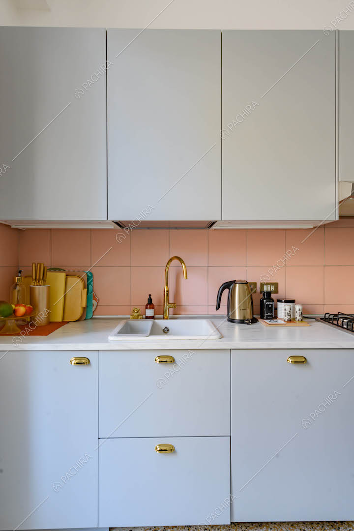 Cucina a parete con piano da lavoro in marmo bianco e paraschizzi rosa