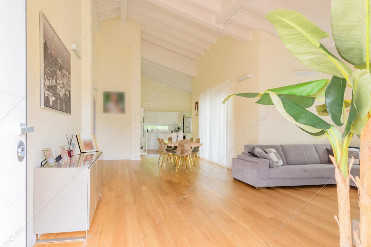 Pavimento in parquet nella luminosa sala con travi bianche a vista sul soffitto