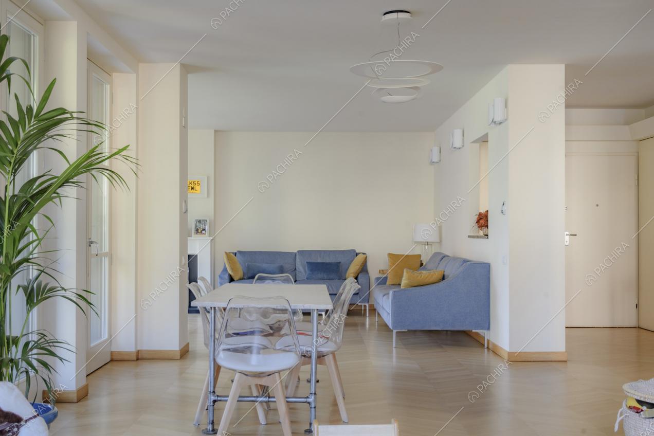 Zona giorno con pareti dai colori chiari, tavolo da pranzo e divani