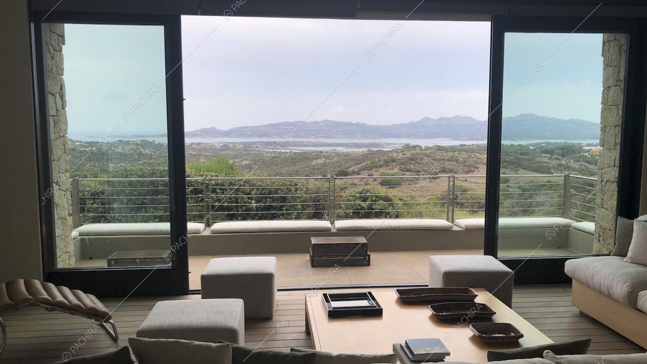 Terrazza con vista mare, pouf bianchi e tavolino quadrato