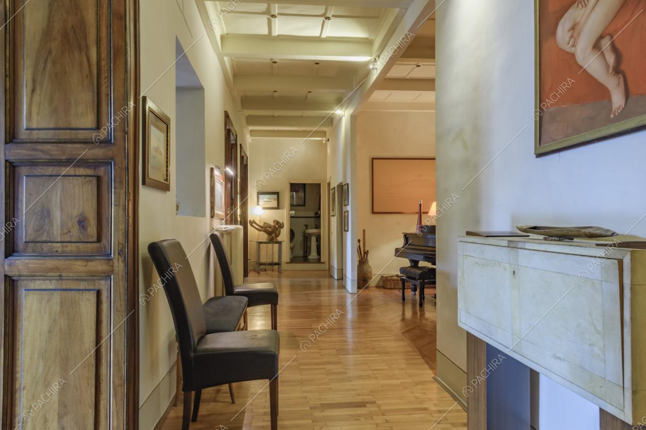 Sedie in pelle, scultura e parquet nei disimpegni