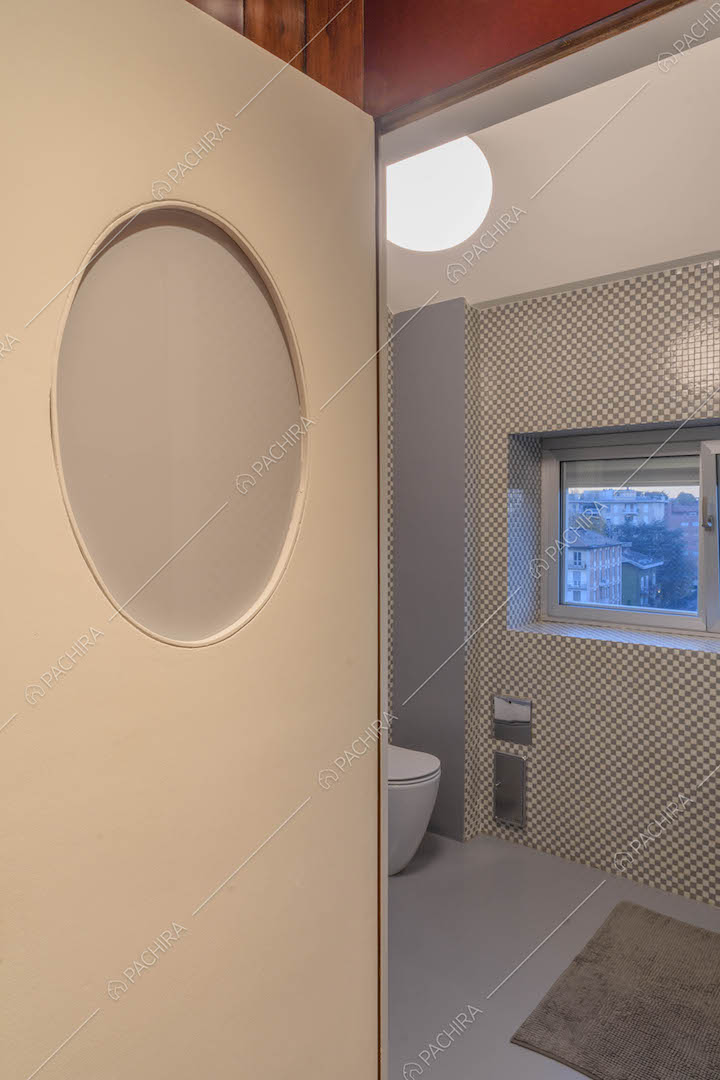Bagno con parete in piccole piastrelle grigie e bianche