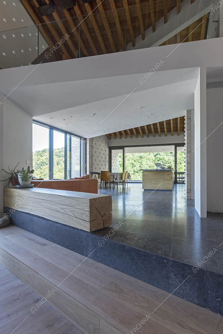 Sala con pavimento in marmo illuminata dalle grandi vetrate e soffitto in travi in legno a vista