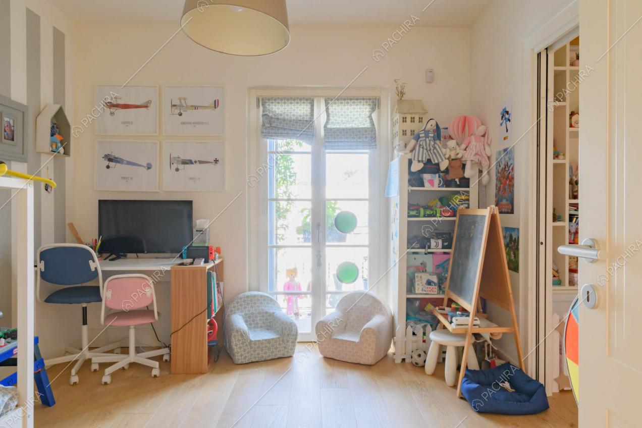 Porta-finestra nella camera da letto dei bambini con pavimento in parquet