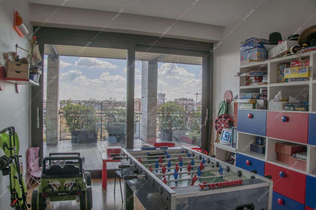 Stanza con giochi per bambini e biliardino con accesso alla terrazza da porta-finestra scorrevole