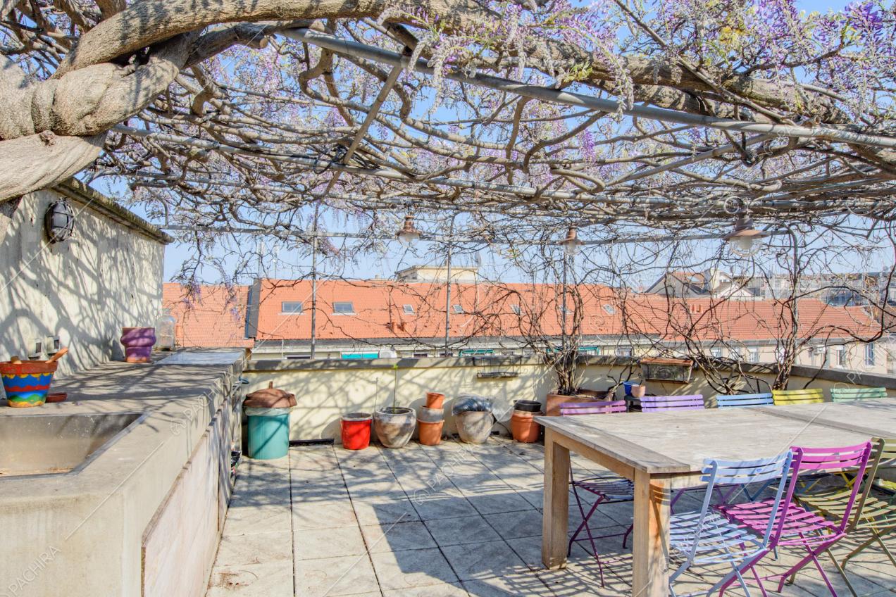 Tavolo da pranzo e sedie colorate in metallo sulla terrazza con tetto in glicine