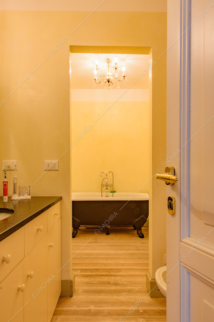 Vista sul bagno con vasca nera e pavimento in parquet