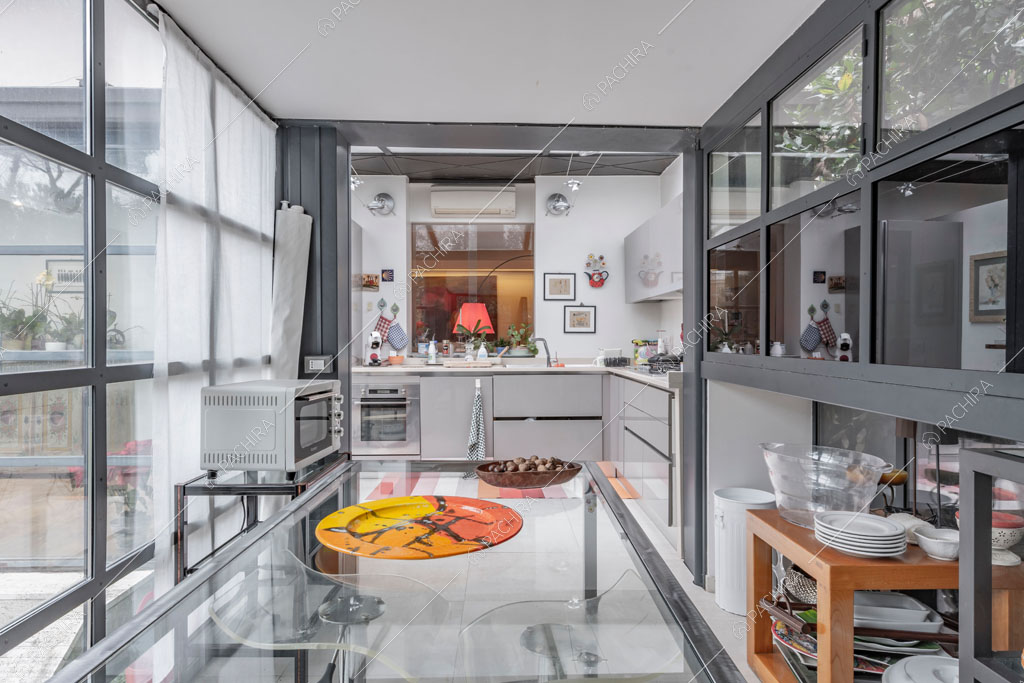 Cucina a parete con pareti vetrate dell'appartamento Catalpa, location in stile moderno a Roma