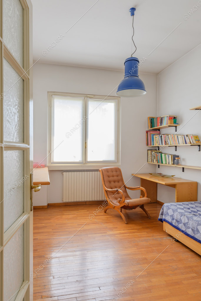 Camera da letto con pavimento in parquet e scrivania in legno