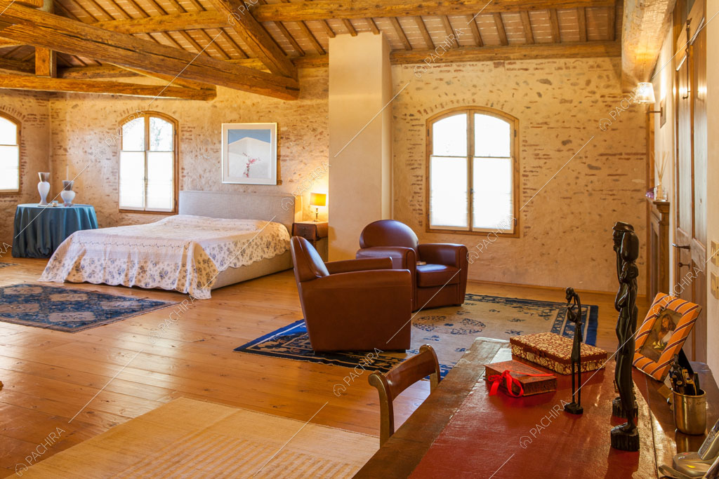 Pavimento in parquet nella camera da letto matrimoniale con pareti in mattoncini a vista