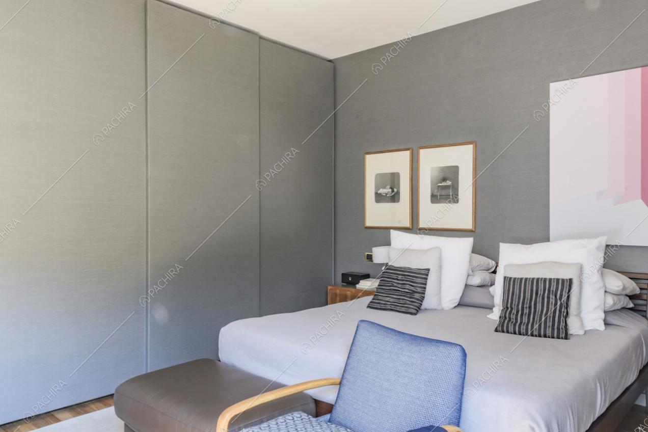 Armadio moderno color grigio vicino al letto matrimoniale