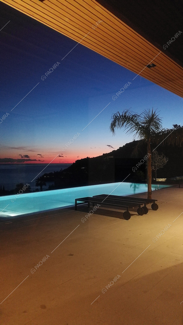 Terrazza al tramonto con piscina a sfioro vista mare illuminata