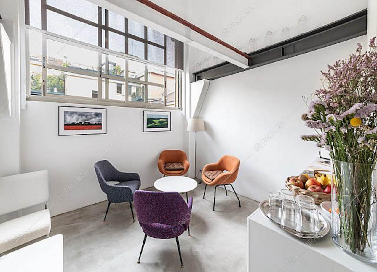 Sala con pareti bianche, finestre in stile industriale e pavimento in resina