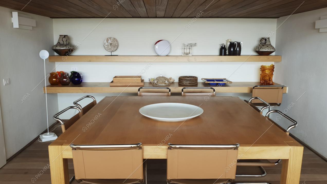 Tavolo da pranzo quadrato e mensole di legno con soprammobili