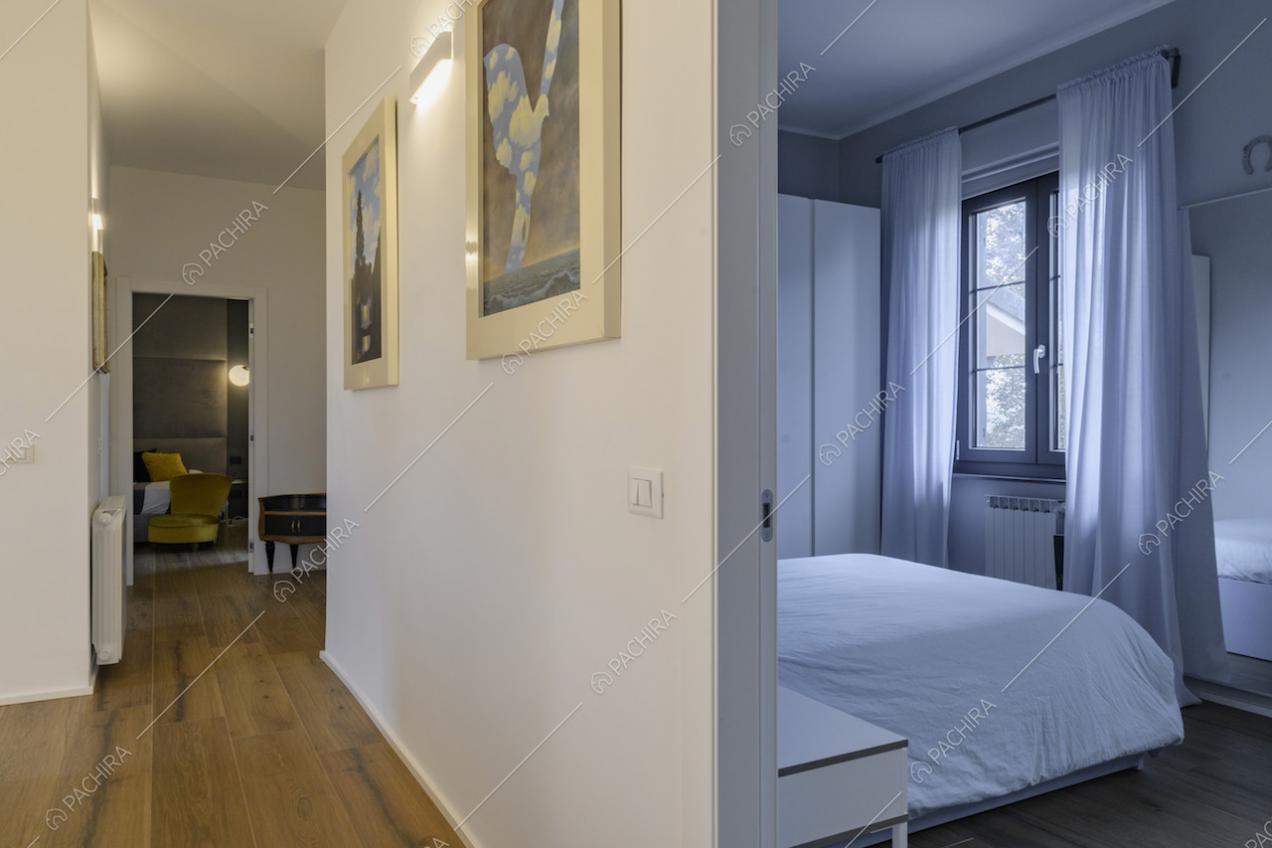 Scorcio sulla camera da letto e quadri appesi alle pareti del corridoio