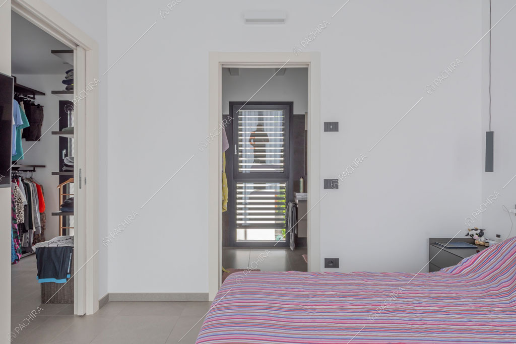 Camera da letto con cabina armadio della villa Diosma, location in stile moderno a Milano