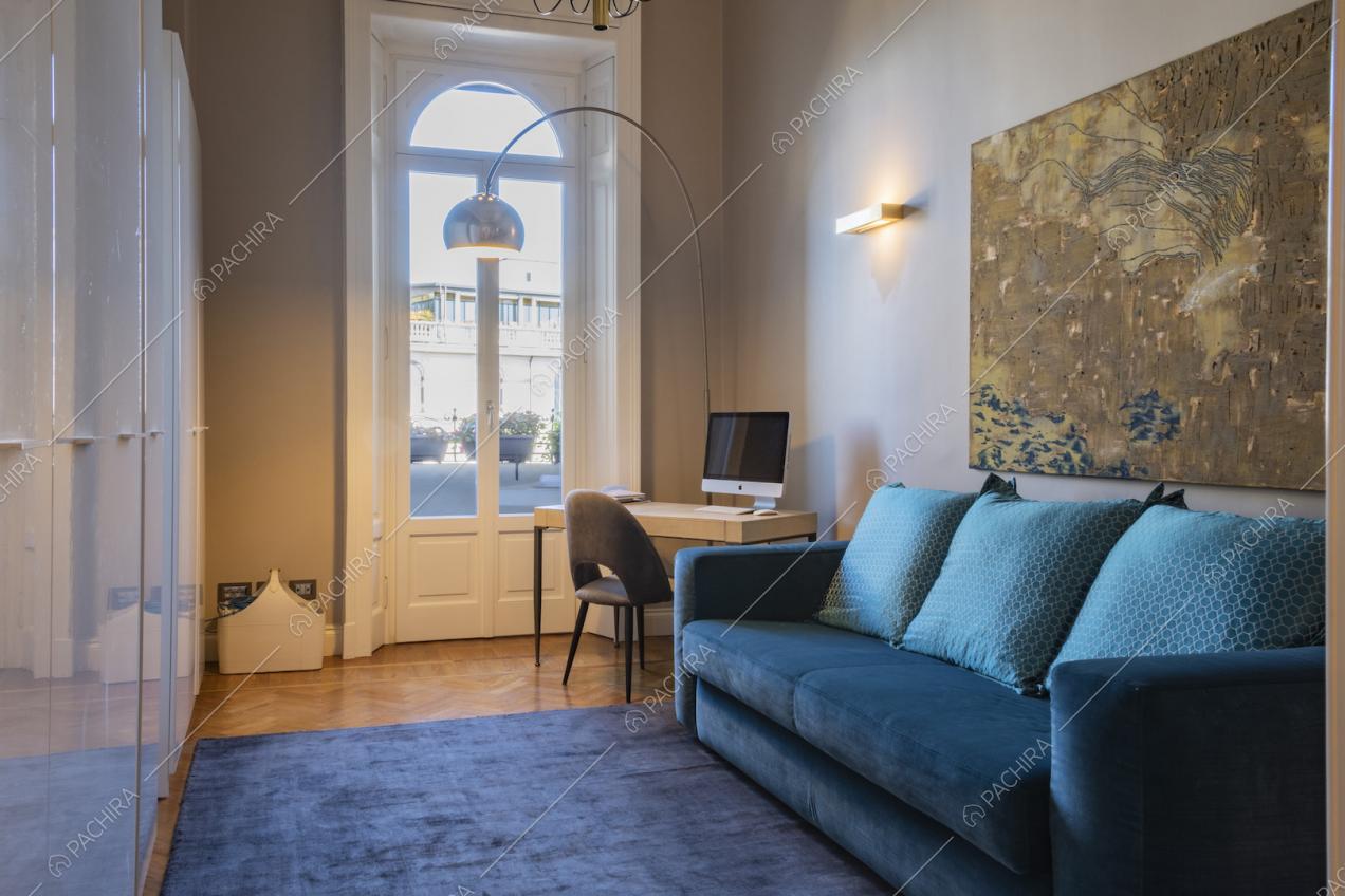 Salottino con divano blu e porta finestra