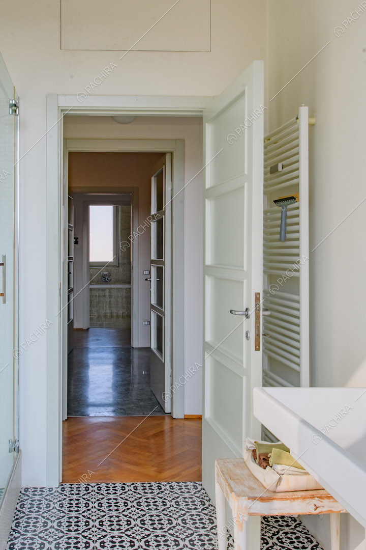 Dal bagno con pavimento in piastrelle nere e bianche vista sul bagno con vasca