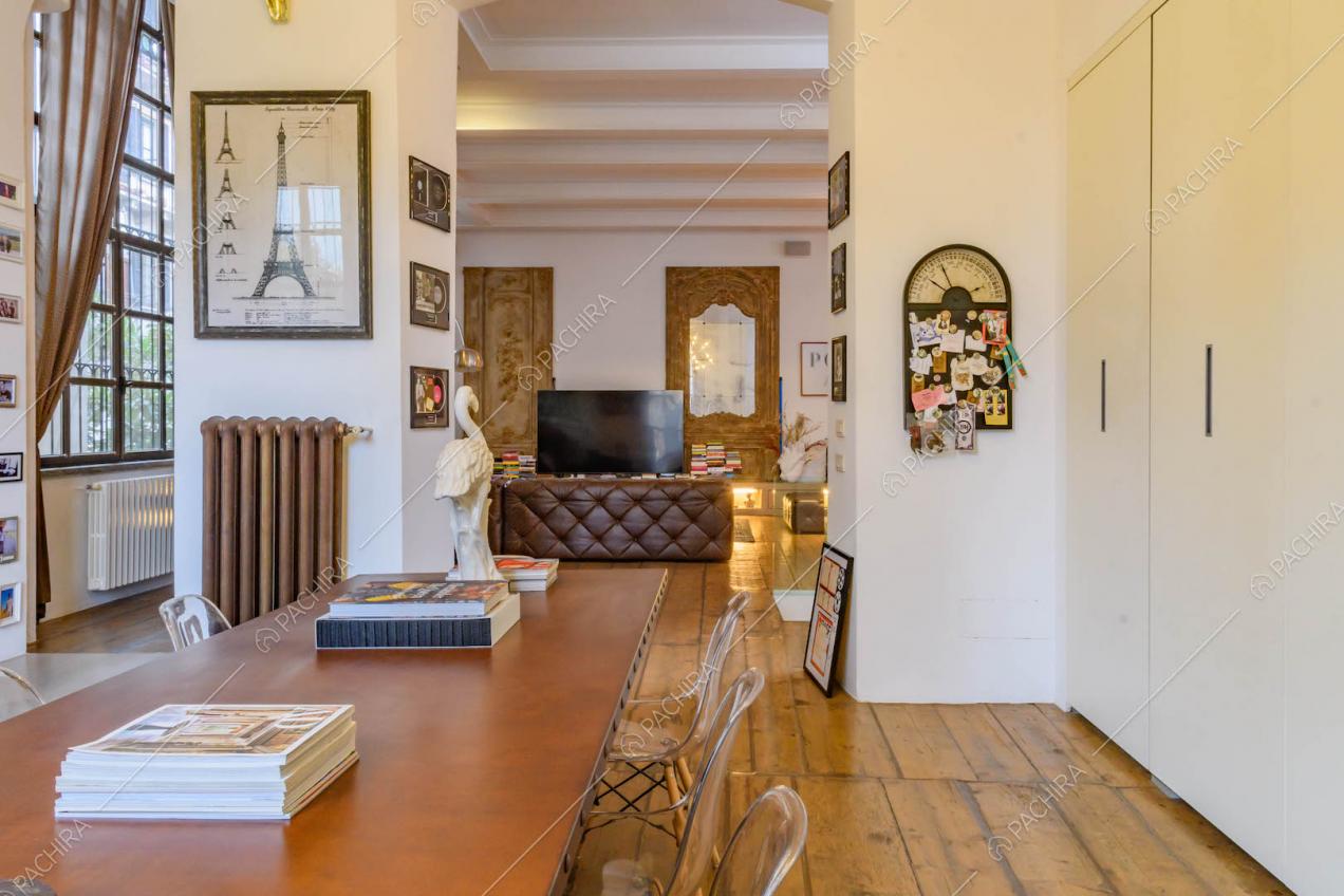 Tavolo da pranzo nella sala con pavimento in parquet e pareti bianche