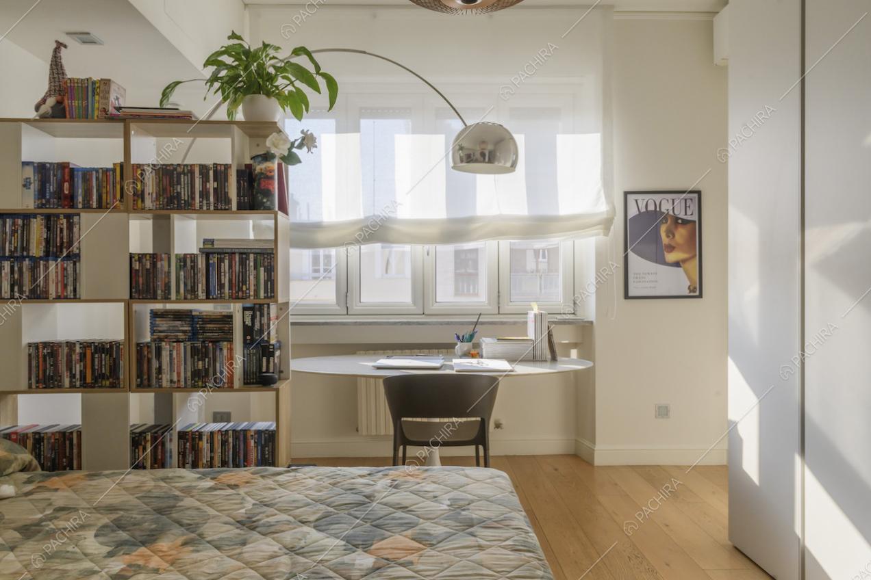 Camera da letto con area lettura e pavimenti in parquet