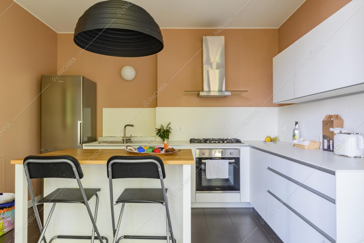 Cucina bianca a muro con fornelli a gas e bancone