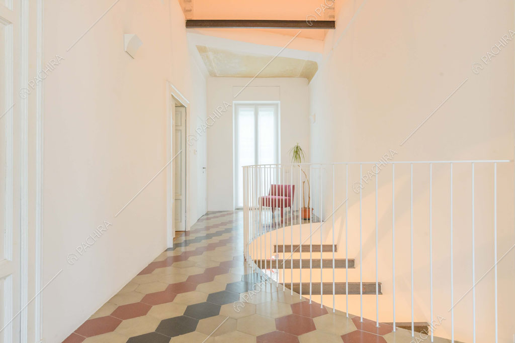 Pavimento in cementine colorate e pareti bianche al primo piano della villa