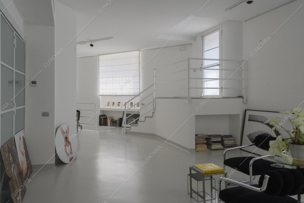 Soppalco con ringhiera bianca e arredi minimal