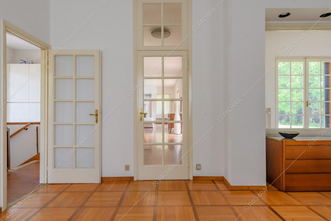 Pavimento in parquet nel corridoio con porte a vetri bianche