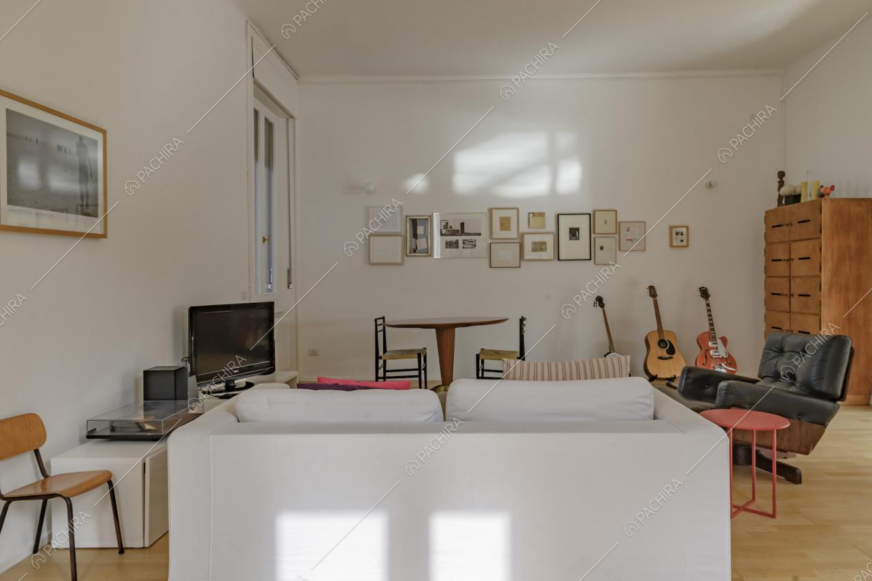 Zona living con divano bianco e poltrona di design 