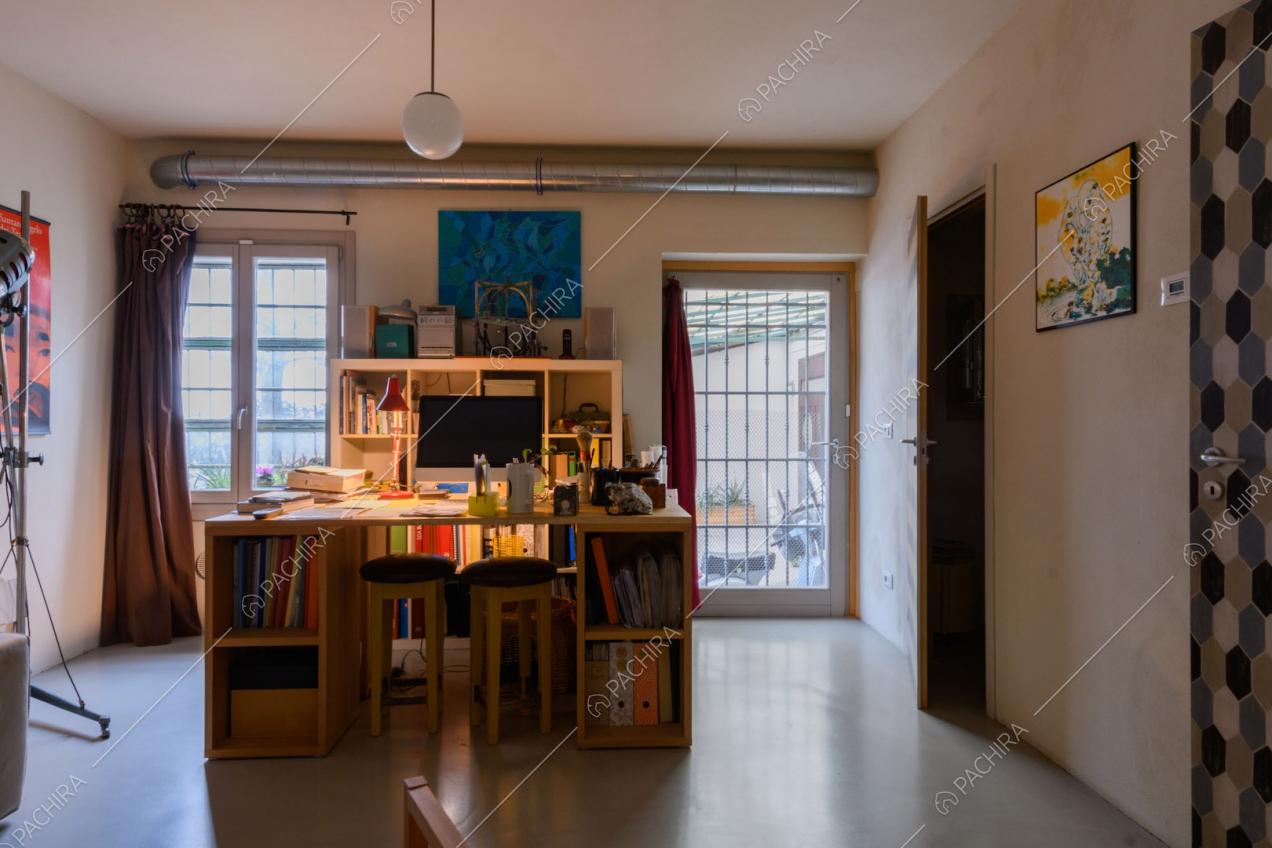 Luminoso studio con pavimento in resina e scrivania con sgabelli