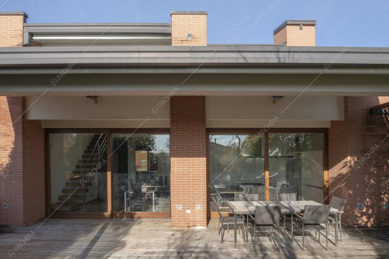 Patio ombreggiato con tavolo da pranzo e sedie da esterni